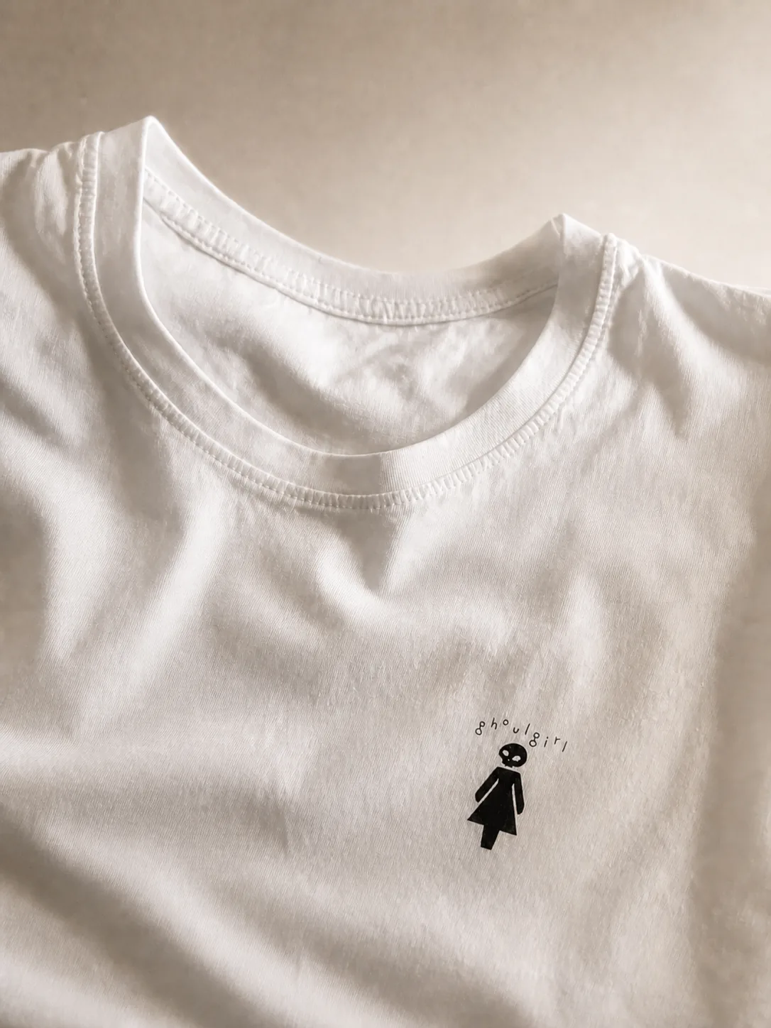 Editorial close-up of the white ghoulgirl t-shirt and its printed design